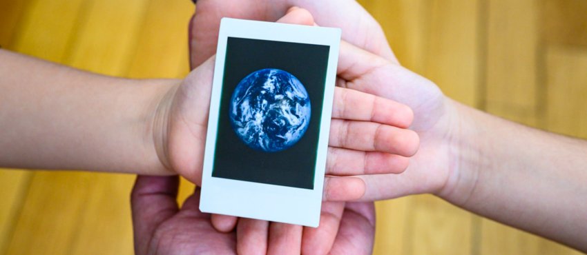 hands holding photo of the earth